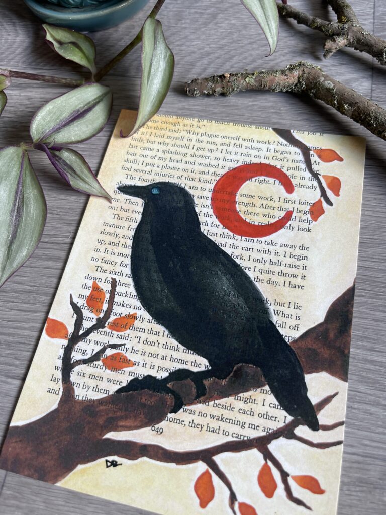 Crow watercolor painting on a book page by Dionne for intuitive self discovery and setting intentions example