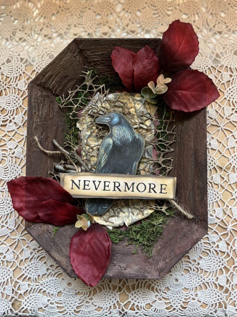 Mixed media art with wood, moss, leaves, and the image of a raven inspired by Edgar Alan Poe for The Whimsical Mysfit Studio a place for intuitive self discovery and setting intentions